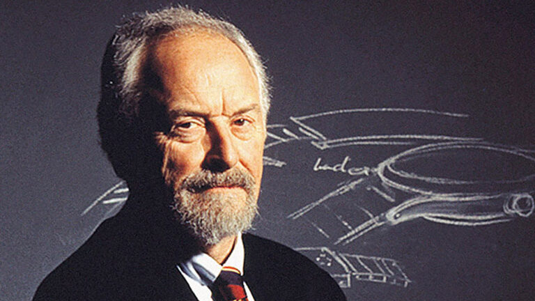 Man in profile view in front of a chalk board