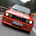 red e30 m3 driving on mountain road