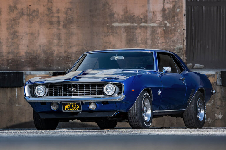 1969 blue camaro ss next to a warehouse