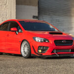 red Subaru WRX next to warehouse