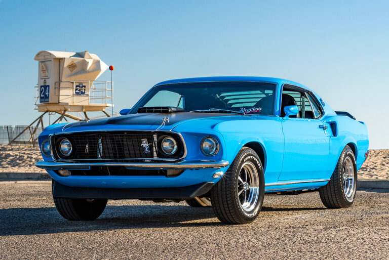 blue mustang mach 1 at a beach