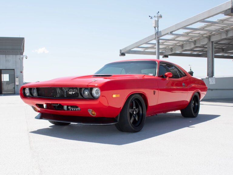Red 74' Dodge in parking structure with blue sky in background