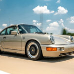 silver 911 on highway with clear sky in background