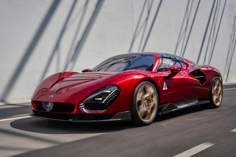 Red Alfa Romeo 33 Stradale driving on the street passing a white wall with shadows on it