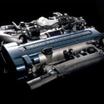 2JZ engine with a blue valve cover and the engine is on a solid black background