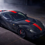 Blue grey Ferrari 812 Competizione with red stripe in a smoky garage, dark background