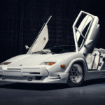 White Lamborghini Countach butterfly doors open on black background