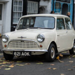 white morris mini minor on a city street