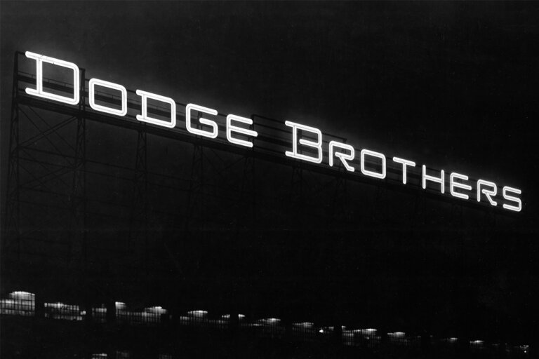 Black and white photo of a sign that says Dodge Brothers with a really dark black background