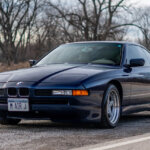Blue BMW E31 parked on the side of the road