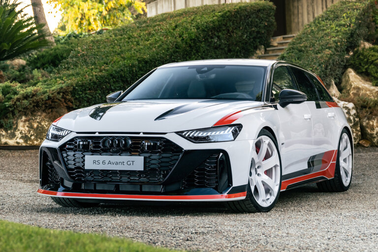 White with red trim Audi RS6 Avant GT parked in front of some green bushes