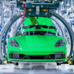 green porsche 718 being assembled on a production line