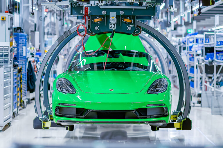 green porsche 718 being assembled on a production line