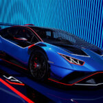 blue lamborghini STJ parked at an angle in front of a striped background and red stripe on the ground