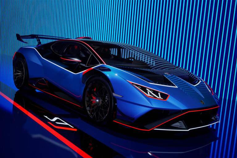 blue lamborghini STJ parked at an angle in front of a striped background and red stripe on the ground