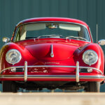 Red Porsche 356 parked in front of a green striped wall