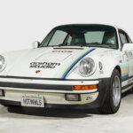 white porsche 930A 911 parked in a garage with a white wall behind it