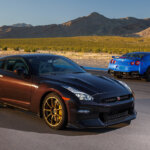 two Nissan GT-R R35's parked next to one another on a racetrack