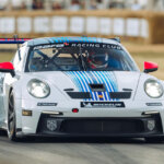 White Porsche 911 992 GT3 Cup race car driven by a man on a racetrack