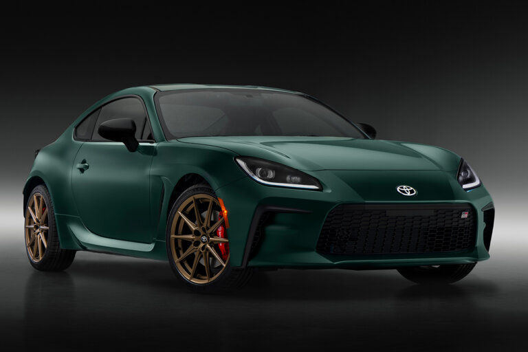 Green Toyota GR86 parked in a dark room with a black background