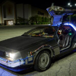 Silver car with driver door opened up with led lights on inside and wrapping the vehicle