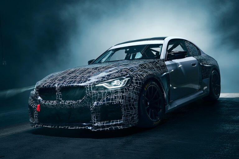 Silver and black BMW with grid lines on the front of the car and smoke behind the car