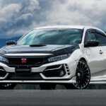 white and black Honda civic type r with red honda badge with cloudy sky in background