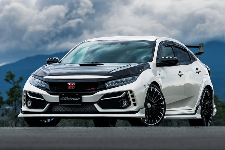 white and black Honda civic type r with red honda badge with cloudy sky in background