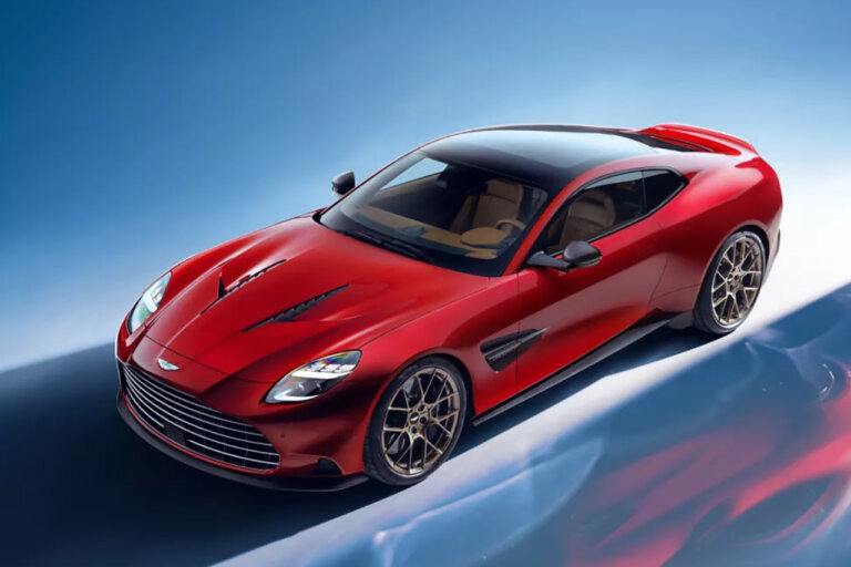 red Aston Martin car parked at an angle on a blue background with reflection of the car on the floor
