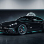 Black and blue accent Mercedes-AMG GT 63 Pro car in a room with a white logo behind the car on a wall with a blue lazer light near the car