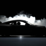 Porsche 911 992.2 car silhouette shot in a dark room with smoke behind it and a driver in the drivers seat