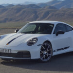 White 911 Carrera T parked at an angle with mountains in the background
