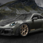 Dark silver Techart 911 parked on the ground with mountains and dark grey clouds in the background