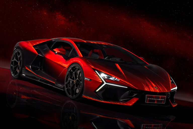 Red Lamborghini Revuelto Opera Unica parked on a stage with the reflection showing on the ground with red background.