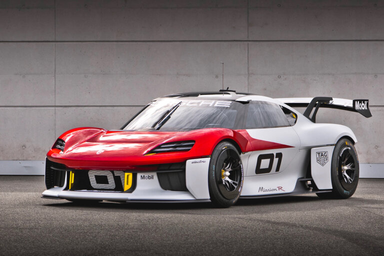 White and red Porsche Mission R parked at an angle in front of a white brick wall with the number 01 on the door.