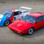 red bmw m1 and white, blue, red bmw m1 procar side by side on asphalt