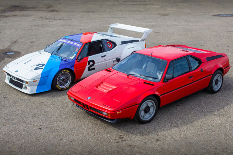 red bmw m1 and white, blue, red bmw m1 procar side by side on asphalt