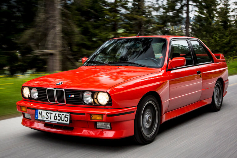 red bmw e30 m3 on a forest road