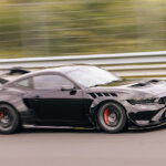 Black 2025 Ford Mustang GTD flying by on the Nürburgring race track.