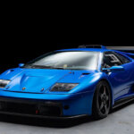 Blu Monterey Lamborghini Diablo GTR parked in a room with concrete floor and black background.