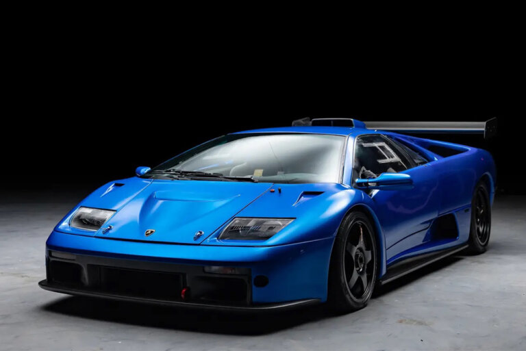 Blu Monterey Lamborghini Diablo GTR parked in a room with concrete floor and black background.