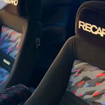 Confetti and black Recaro seats inside of a car.
