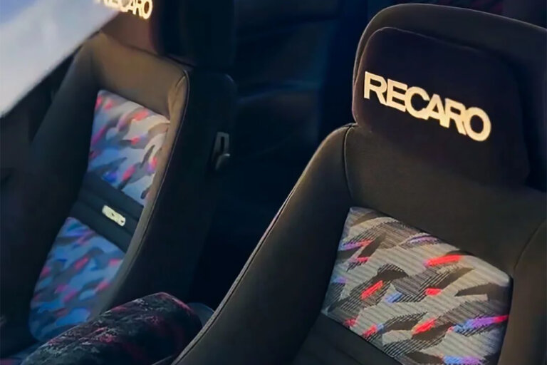 Confetti and black Recaro seats inside of a car.